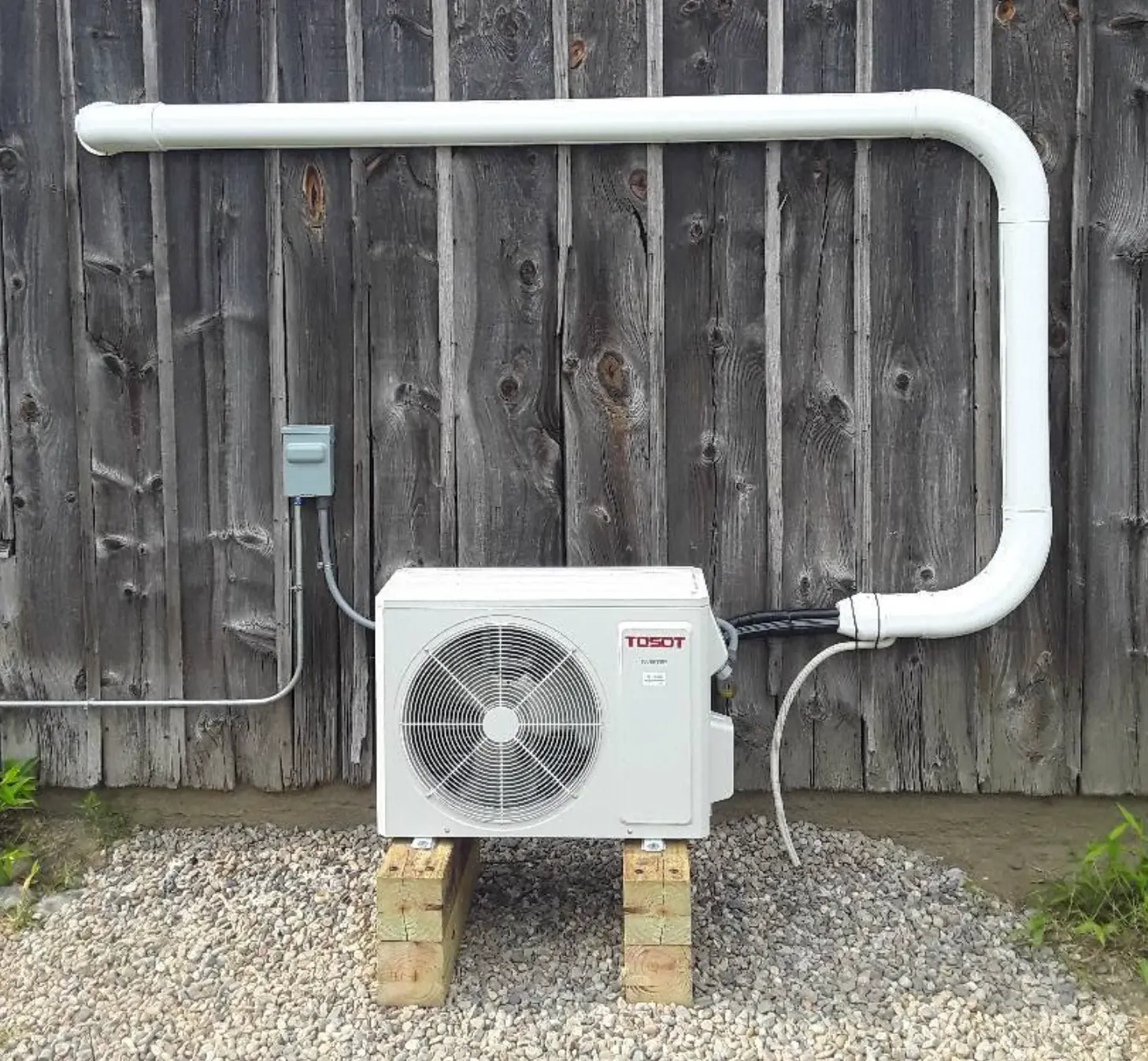 Outdoor ductless mini-split unit installed on a wall bracket